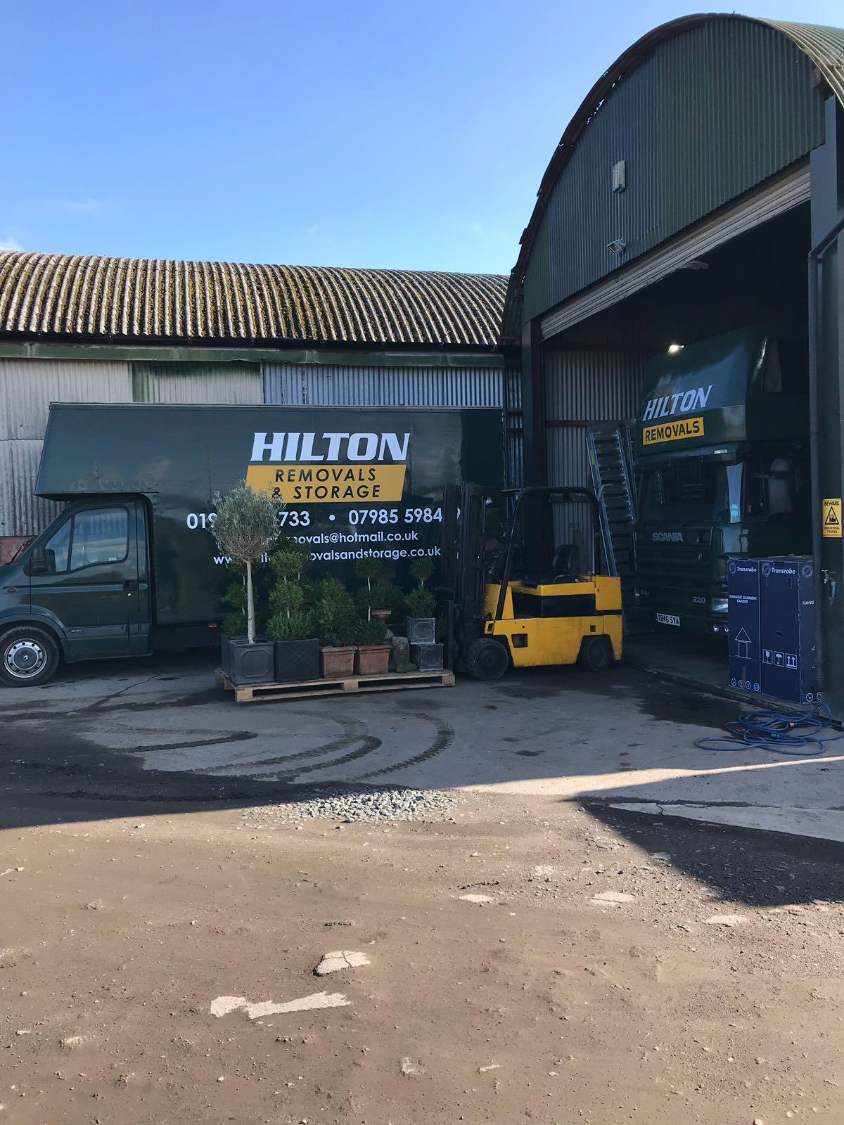 Hilton vehicles and a forklift outside the depot