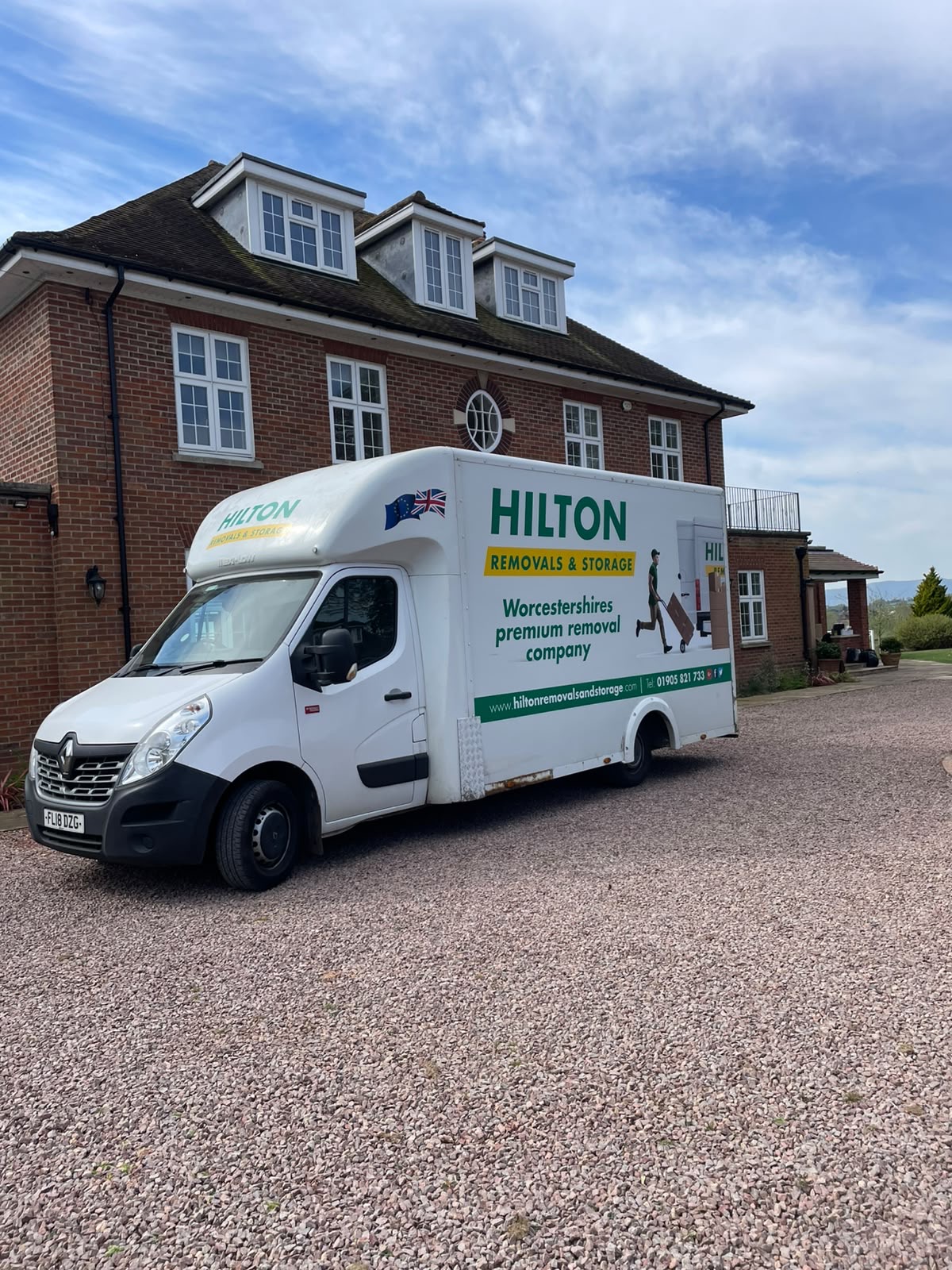 Hilton removal van on the driveway of a brick house